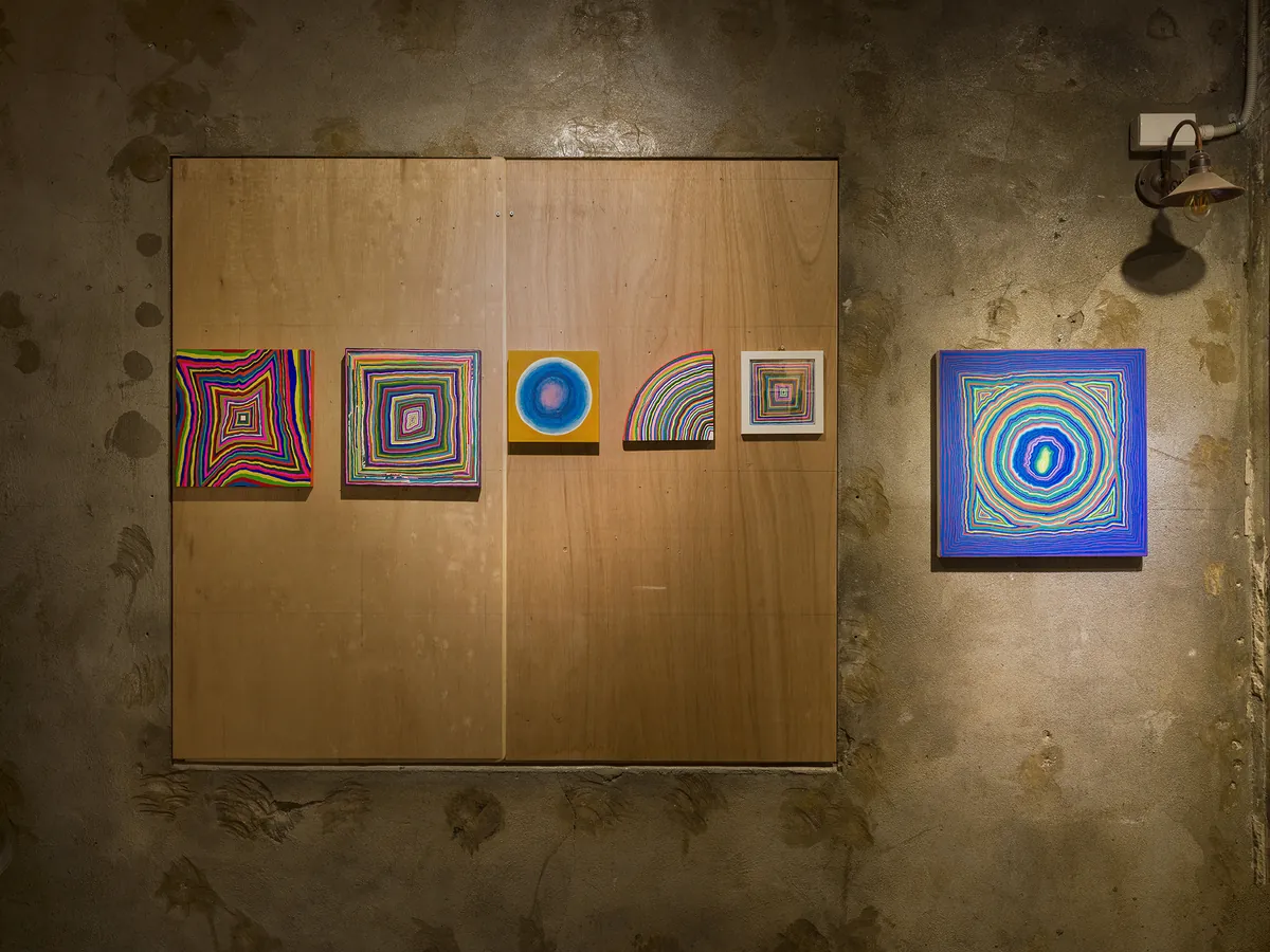 Installation view — small colorful works on a plywood panel